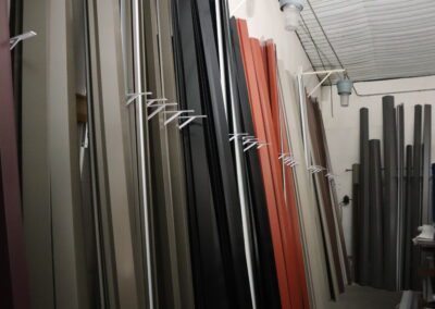 Warehouse with various colors of vertical aluminum profiles stored upright.